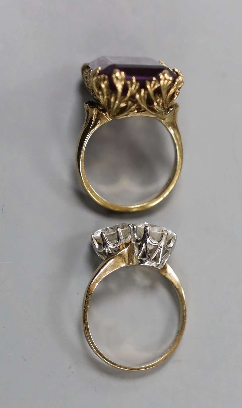 A modern 9ct gold and two stone simulated diamond set crossover ring, size Q and a yellow metal and synthetic colour change corundum set dress ring, gross weight 16.2 grams.